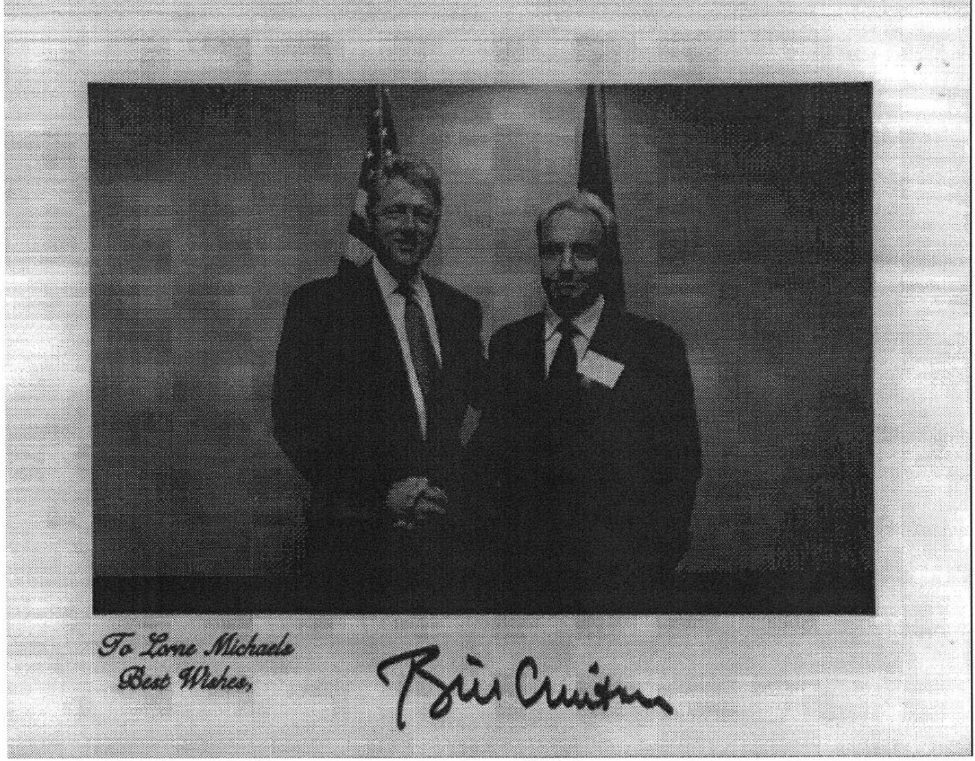 A holiday card, signed by Bill Clinton with message "To Lorne Michaels / Best wishes," featuring a picture of Clinton and Michaels holding hands in front of an American flag.