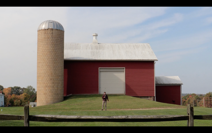 Matt Barats standing in front of a barn and silo.