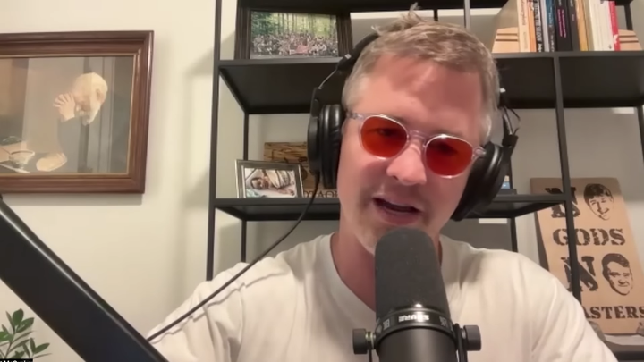 Matt McCusker sitting in front of a podcast microphone.